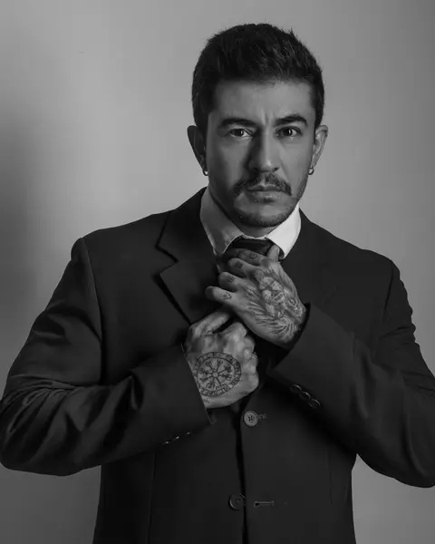 Valmir Lira de terno, retrato em preto e branco, ajustando a gravata